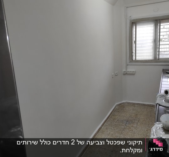 קיר צבוע בלבן עם כלים לצביעה על שולחן